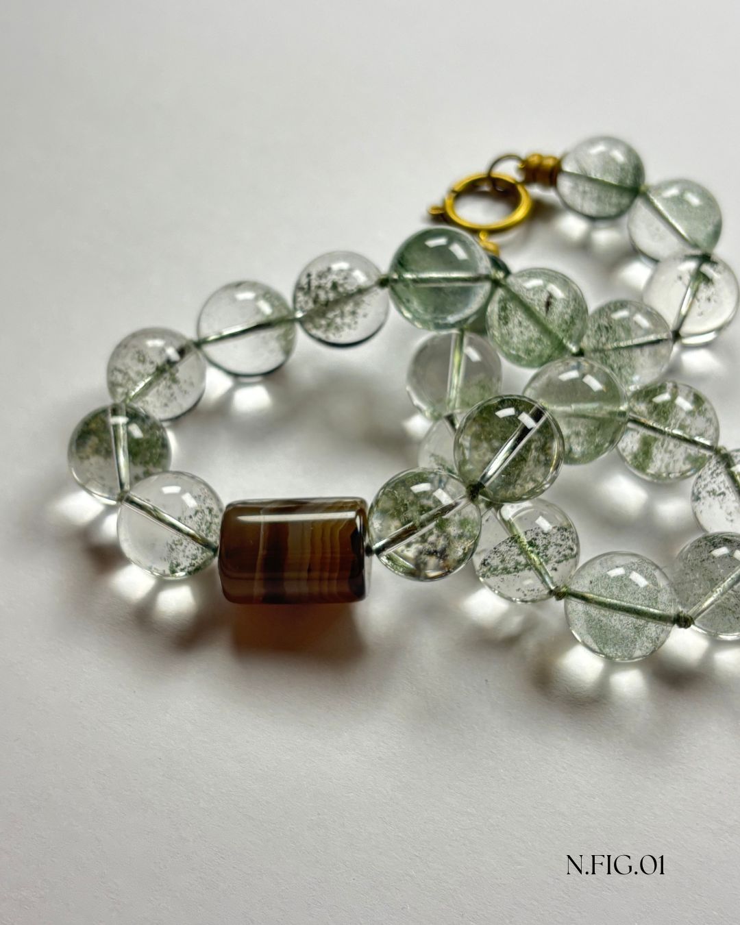 Close-up of a 16-inch necklace made with phantom green quartz and grey lace agate beads, strung together on silk. The green and grey tones create a serene, earthy aesthetic.