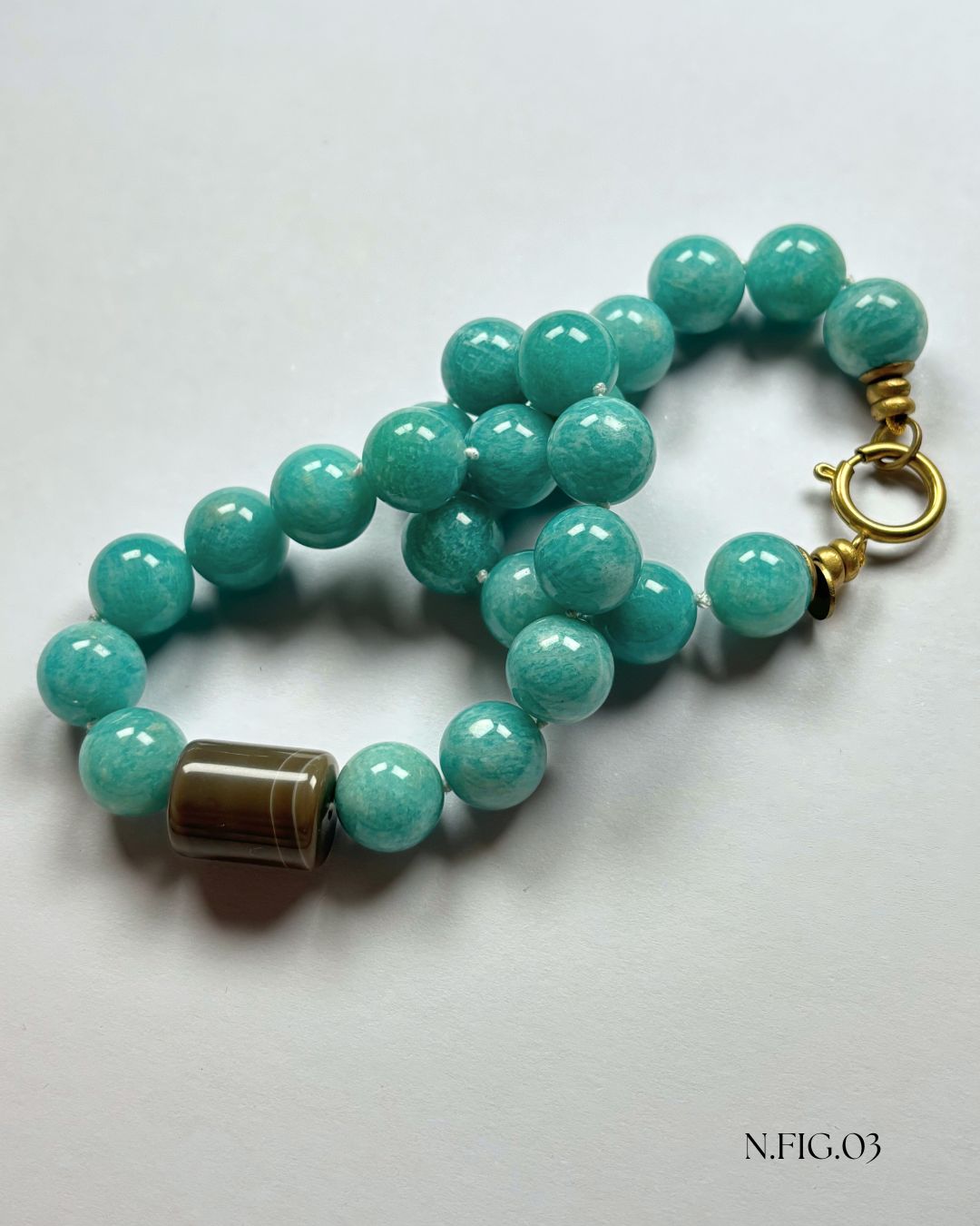 Delicate 16-inch necklace composed of amazonite turquoise and grey lace agate beads, woven on silk. The mix of aqua and grey stones suggests tranquility and balance.