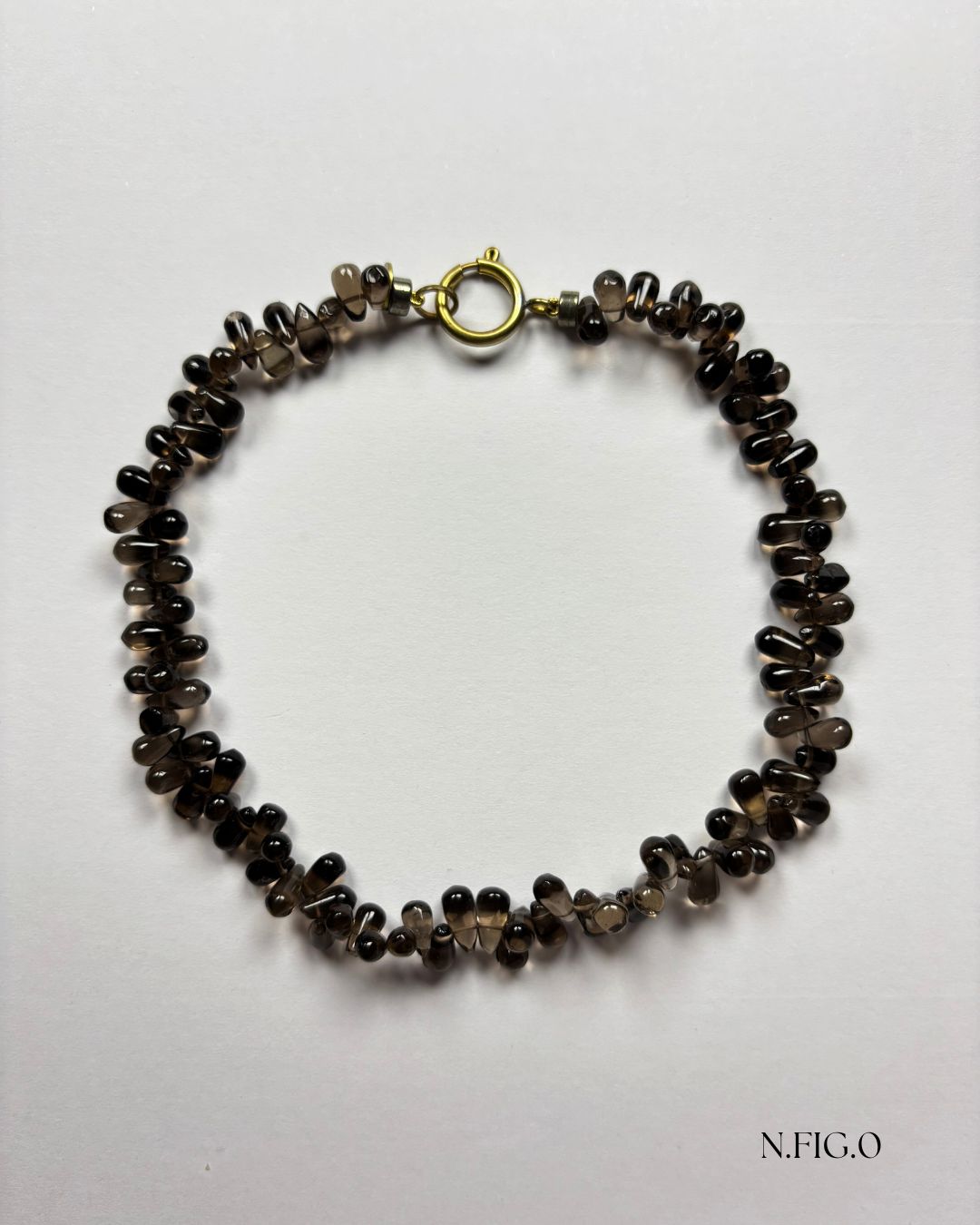 Handmade smoky quartz crystal necklace with polished drop beads on white background