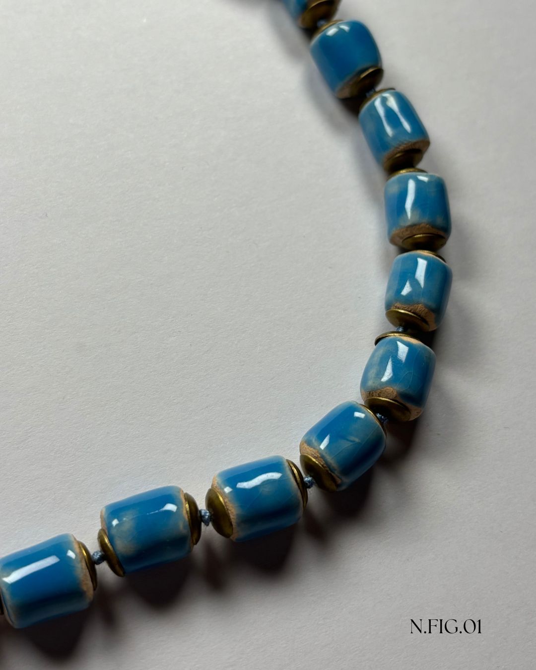 Detail of blue barrel-shaped Czech beads with ceramic-style picasso edging.