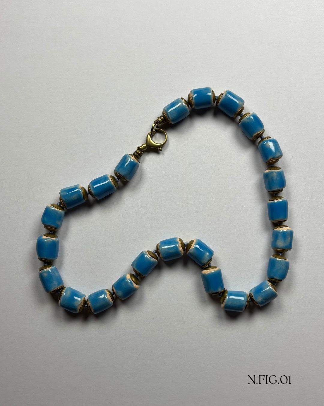 Modern bohemian-style necklace crafted with blue Czech glass and bronze accents.