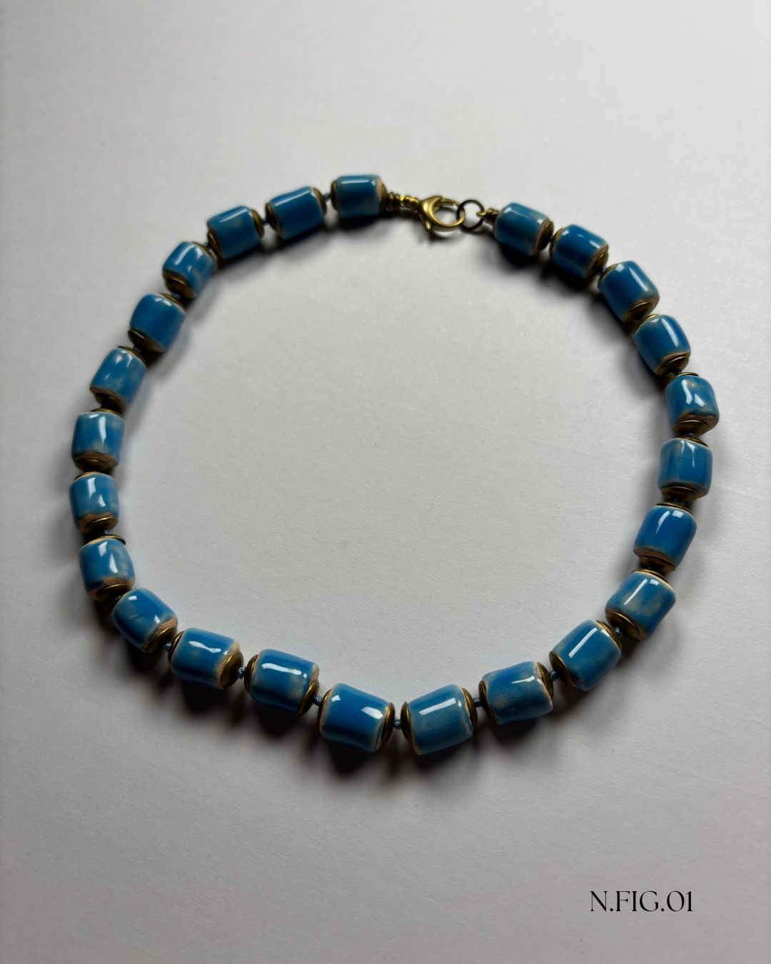 Close-up of artisan Czech glass beads in sky blue with bronze-toned spacers.