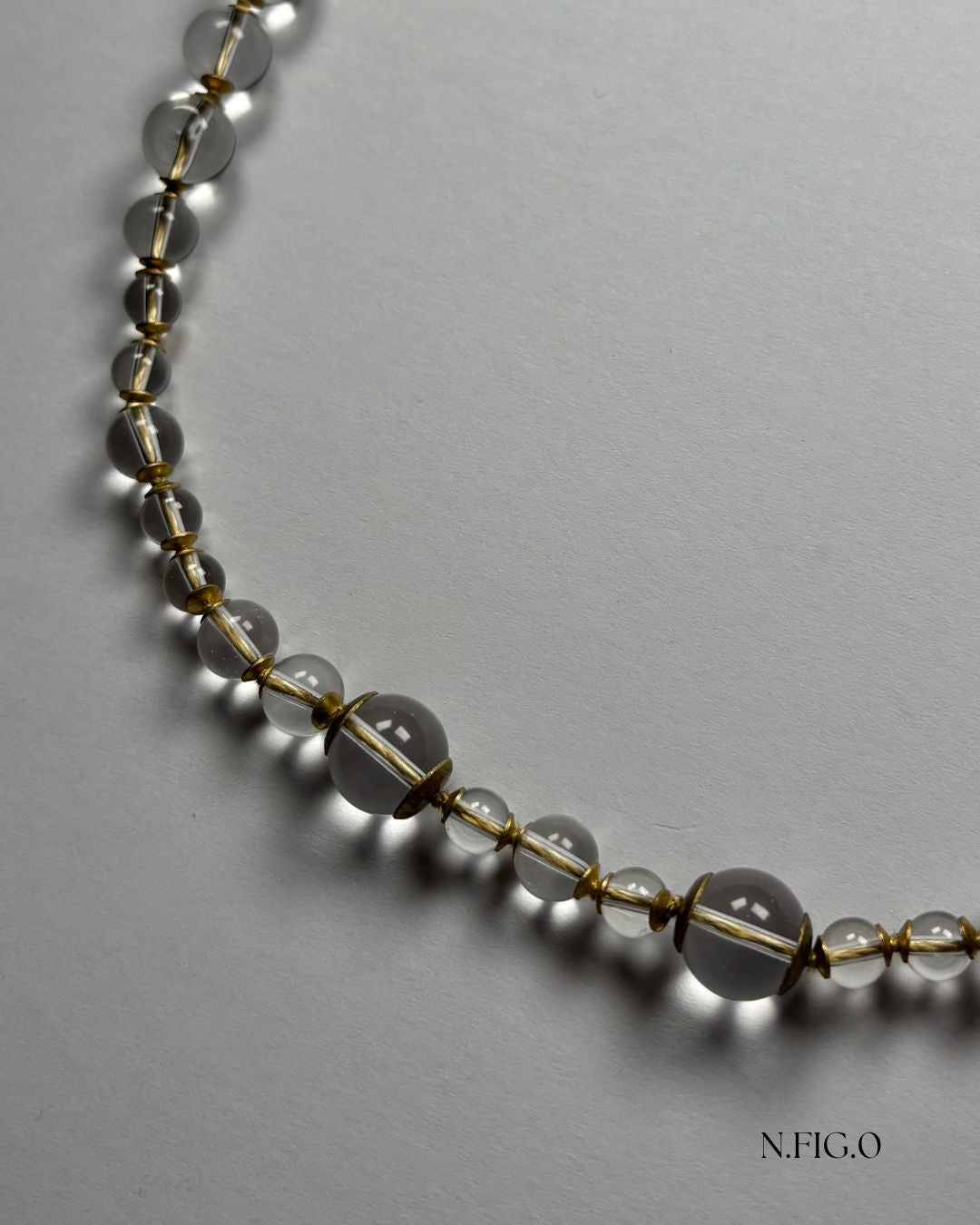 Close-up of natural clear quartz beads with light-catching texture in handmade necklace.